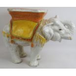 A large tin glazed pottery elephant plant stand/stool decorated in yellow, green and burnt orange