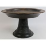 A large 19th century turned oak shallow bowl on splayed pedestal, carved initials TJAP under bowl.