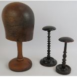 Two antique turned wood ebonised wig stands and an antique hat block on oak stand. Tallest 39cm. (