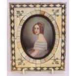 A 19th century continental portrait miniature of a lady in a decorative bone frame. Indistinctly