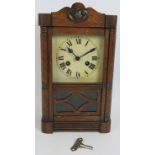 An early 20th century oak cased striking mantel clock with pendulum and key. Height 38cm.