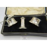 A three piece silver condiment set with fitted liners, Birmingham 1932, 1933 & 1934, boxed.