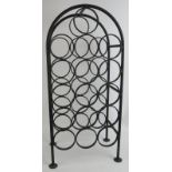 A heavy wrought iron 16 bottle wine rack of arched form standing on pad feet. Height 70cm. Width