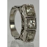 A fine platinum & diamond ring. The three central brilliant cut diamonds in square setting, approx