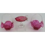 A pair of antique hand blown cranberry glass bon bon baskets and a similar shallow jug with