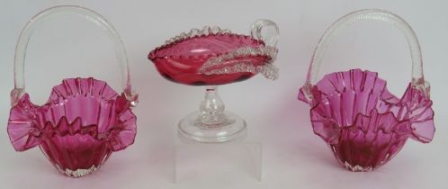 A pair of antique hand blown cranberry glass bon bon baskets and a similar shallow jug with