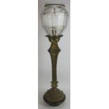 An early 20th century gilt brass newel post lantern with heavy cut glass shade mounted on a tri-form