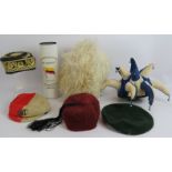 Seven vintage hats including a 1904 cricket cap, fez, green beret and a rolled panama hat in