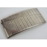 A 1920s silver card case of curved form with machine turned decoration, unengraved cartouche and