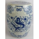 A large Chinese porcelain stool or garden seat with hand finished decoration featuring a dragon