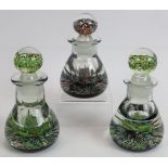 Three signed Caithness glass scent bottles each with the monogram PH (Peter Holmes) in the