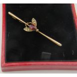 A 9ct yellow gold bar brooch of a winged insect set with centre garnet & each wing with two seed