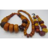 A collection of three graduated extremely large & heavy faux amber, some possibly Faturan necklaces.