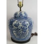 A large blue and white Delft style ceramic lamp base in the form of a covered jar, hand decorated.