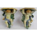 A pair of early 20th century Italian Majolica cherub wall brackets decorated in greens, blues and