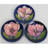 Three small Moorcroft pottery dishes decorated with magnolia flowers. Each incised Moorcroft Made in