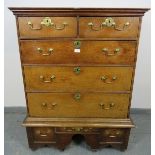 An 18th century medium oak chest on stand, of two short over three long graduated drawers with brass