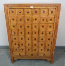 A vintage Chinese elm apothecary cabinet, of 42 short drawers over three long drawers, on square
