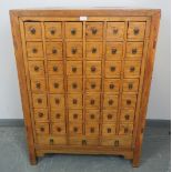 A vintage Chinese elm apothecary cabinet, of 42 short drawers over three long drawers, on square