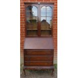 An early 20th century walnut Georgian revival bureau bookcase, on cabriole supports. Condition