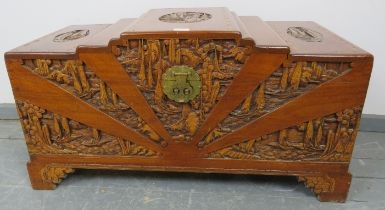 A vintage Japanese camphorwood trunk, with relief carving depicting pagodas amidst foliate scenes
