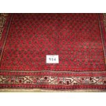 A fine meshed rug central block repeat pattern on red ground with cream patterned border. 2.10 x 1.