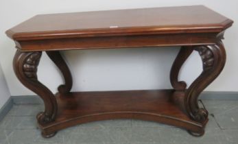 A Victorian mahogany console table, on shell carved and scrolled ogee supports, united by a shaped