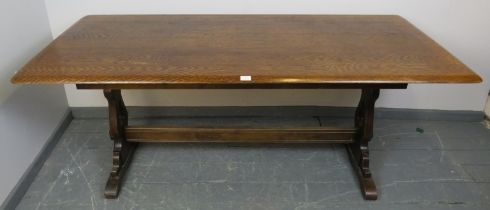 A vintage mid-century elm refectory table by Ercol, on shaped and pierced supports with central