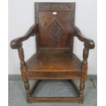 A 17th century and later oak wainscot chair, with relief carved and panelled back, scrolled arms and