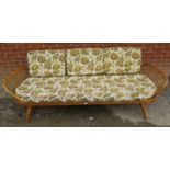 A 1960s Ercol blonde elm daybed, with original green and cream patterned upholstery, on tapering