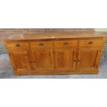 A large contemporary hardwood sideboard of four short drawers with cast scallop handles, over two
