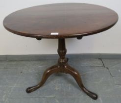 A George III ‘birdcage’ tilt-top table, the oak top on a mahogany tapering column with outswept