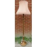 An antique style giltwood standard lamp with baluster turned and reeded column, on a circular plinth