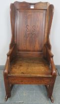 An 18th century fruitwood lambing chair, the panelled back carved with ‘SS 1722’, featuring under