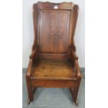 An 18th century fruitwood lambing chair, the panelled back carved with ‘SS 1722’, featuring under