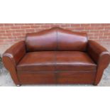 A French Art Deco ‘moustache back’ two-seater sofa upholstered in tobacco brown leather, on block