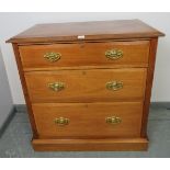 An Edwardian mahogany chest of three long graduated drawers with pressed brass handles, on a