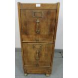 An early 20th century oak two drawer filing cabinet with brass fittings, on castors. Condition