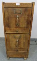 An early 20th century oak two drawer filing cabinet with brass fittings, on castors. Condition