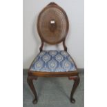 A Georgian Revival walnut occasional chair with carved cornice and radial bergère backrest, the