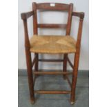 A 19th century fruitwood child’s high dining chair, with rush seat, on turned supports with