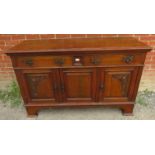 An Art Nouveau carved oak sideboard, housing two short drawers over three cupboards with fitted