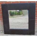 A large contemporary square wall mirror in a black leather surround. Condition report: Some scuffs