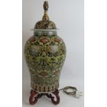 A 20th century Chinese porcelain temple jar style lamp on carved hardwood base. Overall height 66cm.