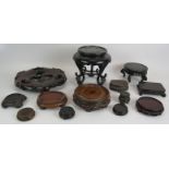 13 Chinese carved hardwood stands of various sizes and woods. Largest 31cm diameter. (13). Condition