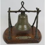 An antique table/dinner bell on patinated bronze naturalistic stand mounted on an oak vase with