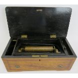 A small antique Swiss music box with lever wind mechanism in an inlaid wooden case. 34cm x 17cm x