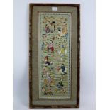 A framed Chinese silkwork panel depicting various figures riding various beasts within an ornate