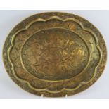 An antique hand beaten Indo-Persian brass dish of oval form with raised rim decorated with birds