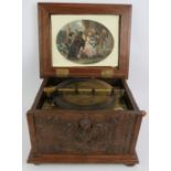 A 7.5" Symphonium disc musical box in carved oak relief case and twelve discs. 33cm x 27cm x 22cm.